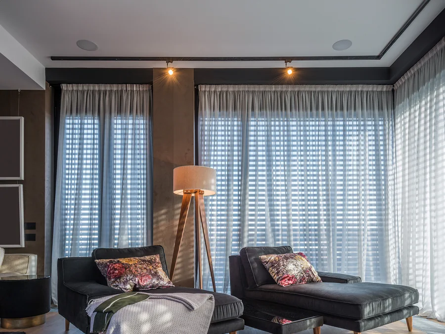 A calm modern bedroom with a Lithe Audio ceiling speaker set flush into the ceiling